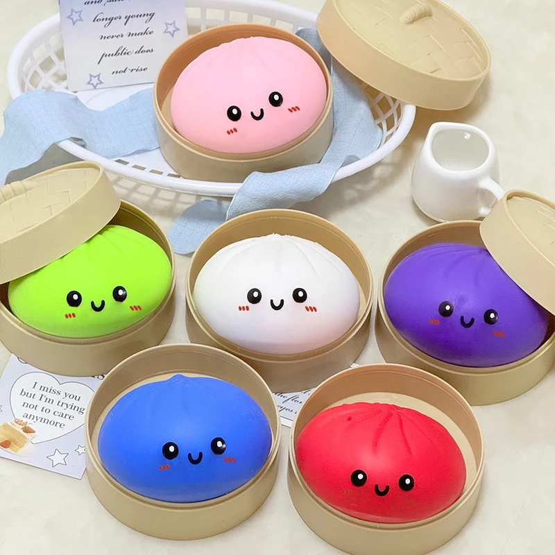 Six squishy bao pastel disposés dans leurs petits paniers vapeur en bambou, sur une table claire